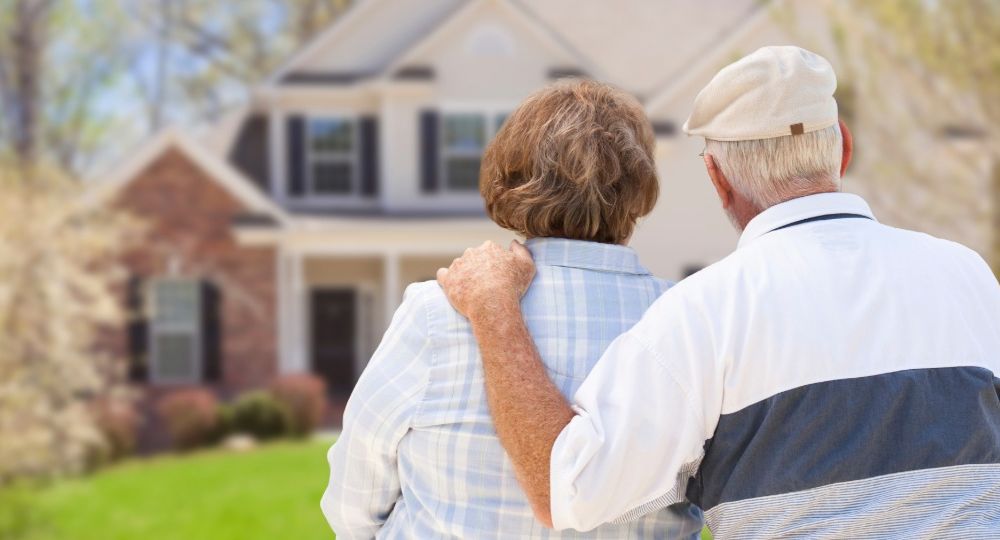 An older New England couple looks at their home while weighing whether a loan modification can stop the foreclosure sale."