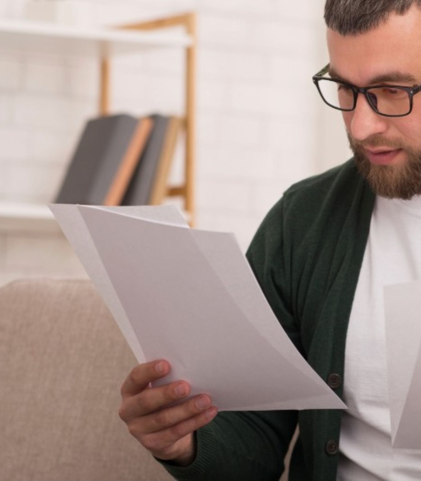 A New England homeowner holds the signed loan modification agreement the new mortgage company must honor, beside a servicing transfer notice.